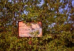 Stara tabliczka rezerwatu Susła - Hubale pod Zamościem. W środku widoczny ślad po kuli.