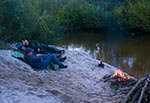 Przebywając nieco dłużej nad rzeką wtórnie zdziczałą (w tym przypadku jest to Tanew) trudno znaleźć miejsce o wypoziomowanej plaży. Nie muszę wspominać o tym, że siedzenie czy leżenie na stromym spadku grozi sturlaniem się do rzeki ;) Trzeba więc takie miejsce przygotować za pomocą widocznej na zdjeciu szufli. Ta akurat składa się z dwóch - stalowa łopata pochodzi z zestawu P-poż z lat 80, a trzonek pochoidzi również z czasów poprzedniego komunizmu - made in CCCP. Poziomowanie gruntu ma również na celu sprawdzenie czy w piasku nie tkwią ewentualne robite butelki czy puszki. Dawniej istniał taki obyczaj pośród turystów, iż śmieci zakopywało się na skraju obozowiska. Rzeka zaś meandrując stale zmienia przebieg koryta i czasem takie stanowiska archeologiczne zostają odsłonięte.